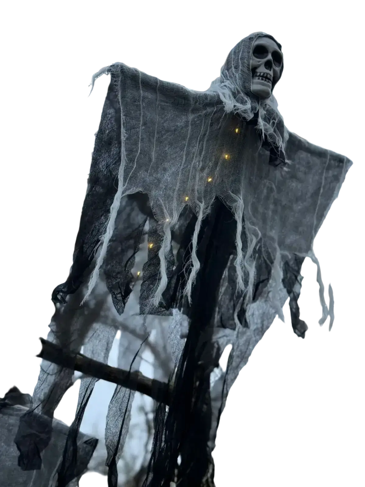 A spooky gray skeletal glowing skull hanging halloween ghost decoration draped in tattered black fabric with yellow lights