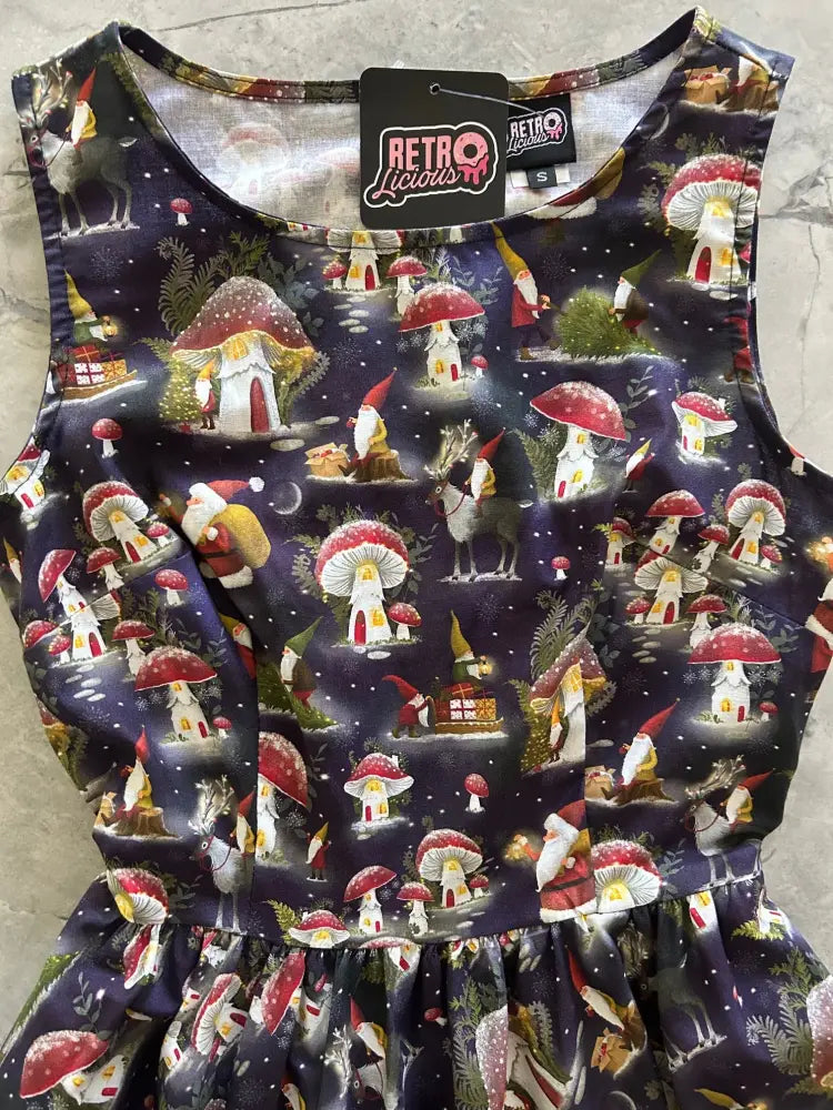 A sleeveless dark navy cotton midi dress with gnome and red-capped mushroom print under a starry night sky