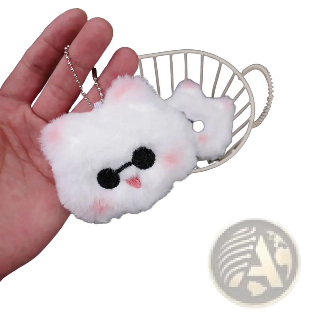 A fluffy white plush cat anime keychain with black embroidered eyes pink cheeks and a tiny tongue from gojo and geto collection