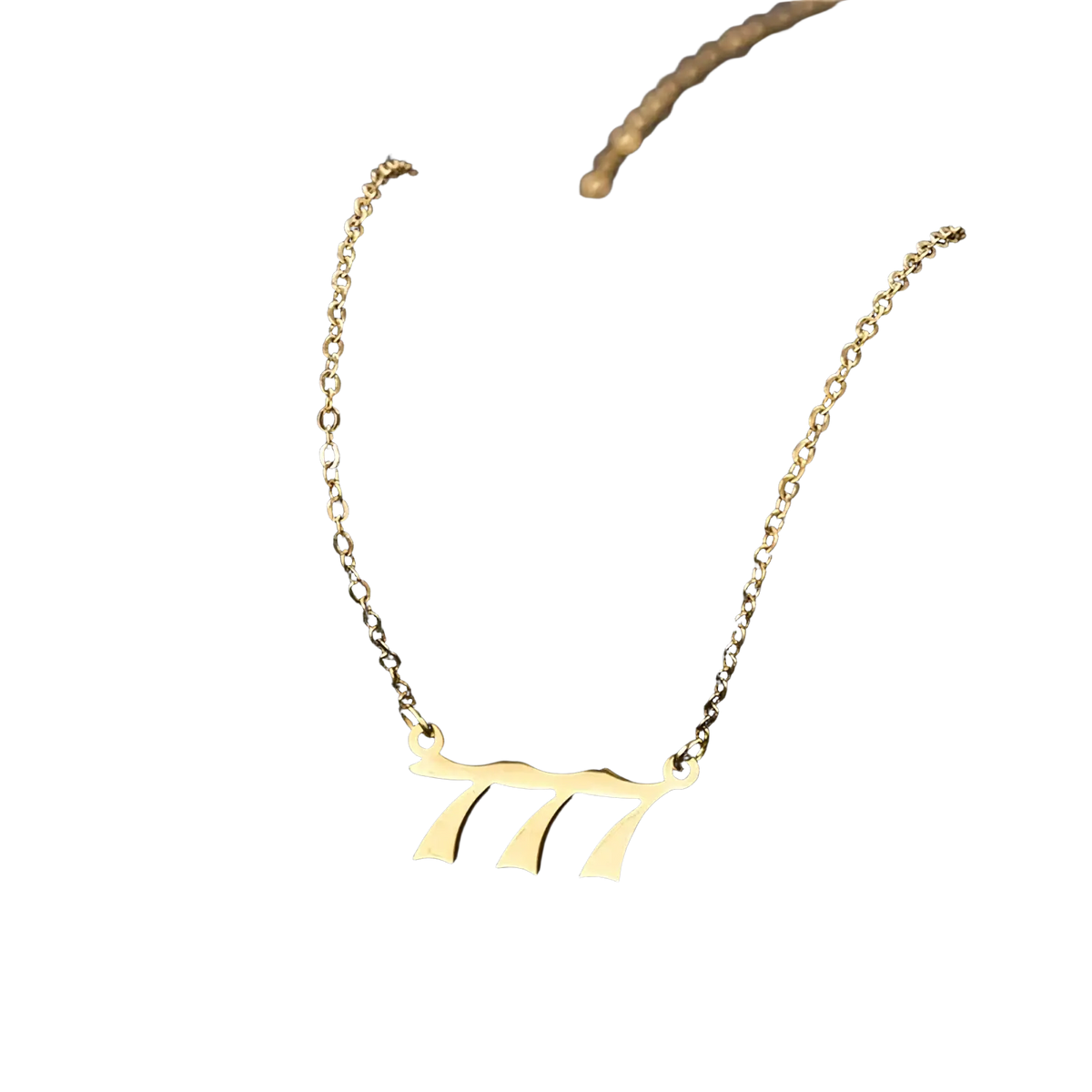 Gold angel number 7 necklace with a gold-toned minimalist pendant shaped like number 777 in elegant cursive font