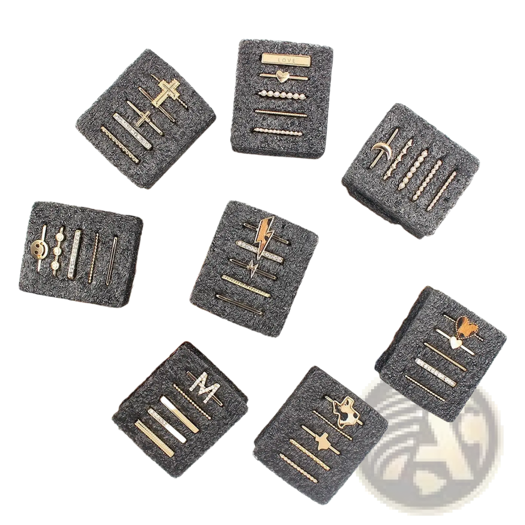 Gold-toned hairpins with intricate designs and sparkling embellishments in black textured boxes from gold embellished silicone strap decorative ring set