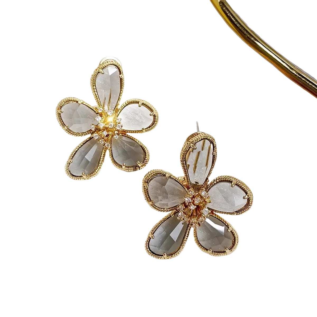 Gold flower crystal stud earrings with gold-toned metal, faceted gray crystal petals, and clear crystal center cluster