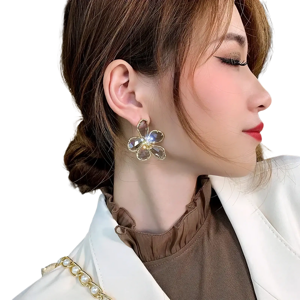 Gold flower crystal stud earrings featuring gold-toned metal with clear faceted crystal petals and central diamond accents