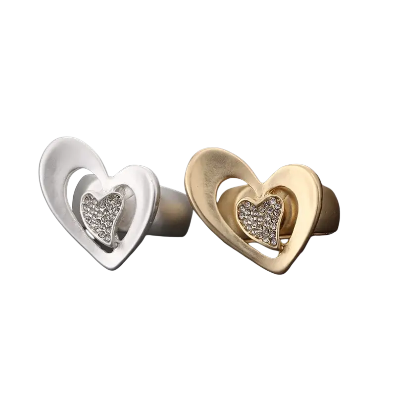 A pair of heart-shaped adjustable rings in gold and silver with rhinestone-embedded smaller hearts