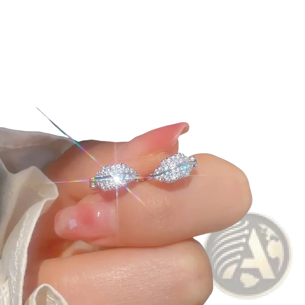 A delicate silver ring with two interlocking leaf-shaped designs adorned with clear crystals in stainless steel