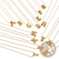 Gold-colored balloon-shaped letter necklaces on delicate layered snake chains made of fine metal