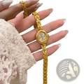 Gold luxury women’s bracelet watch with an ornate oval face and matching gold-toned chain-link band