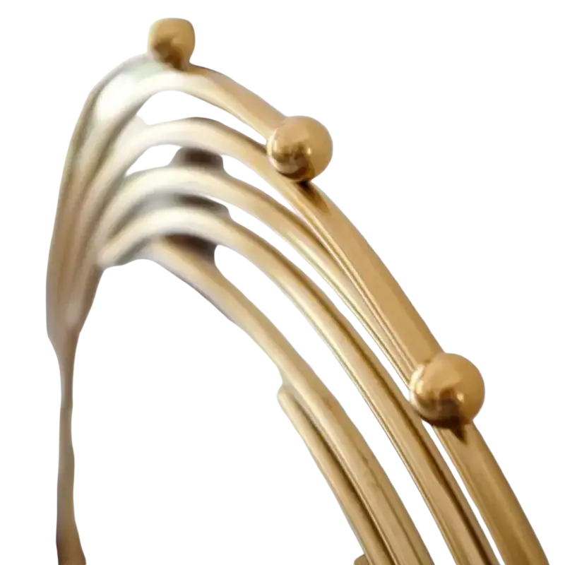 Gold metal abstract sculpture office desk decor featuring a gold-toned metal mirror frame with curved arched bars and spheres