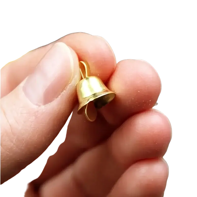 A tiny gold metal sleigh bell with a looped top held between fingers from a set of 20 pcs