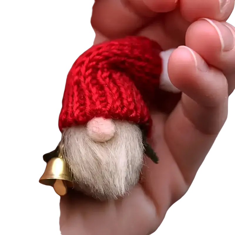 A tiny red knitted gnome ornament with a fluffy white beard and a small golden bell from gold metal sleigh bells set