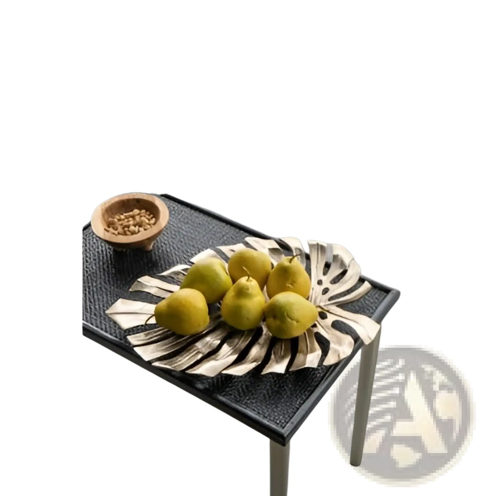 Black textured table with white legs displaying gold monstera leaf wall decor and serving tray in elegant setting
