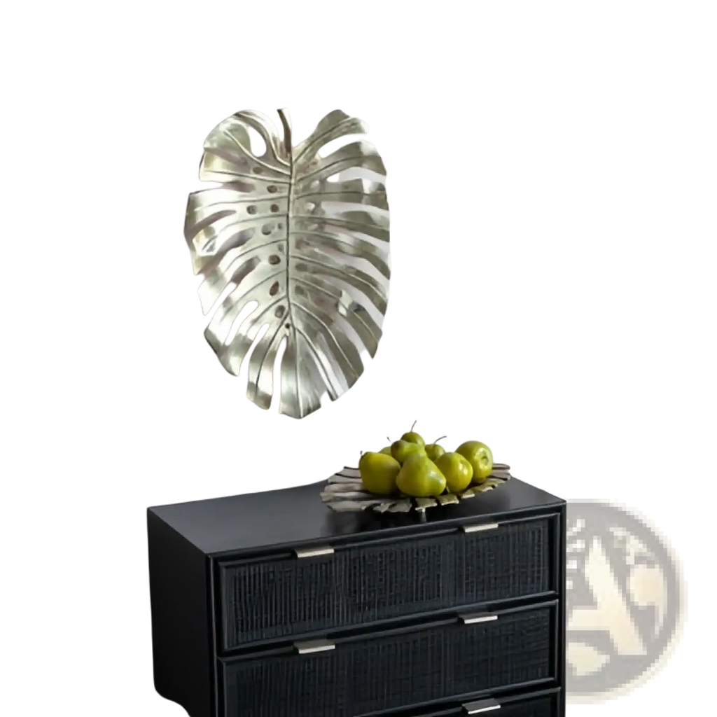 Silver metallic monstera leaf wall decor contrasting with the gold monstera leaf serving tray in a modern design