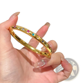 Gold multicolored gemstone bangle bracelet featuring a gold-toned band with vibrant multicolored gemstones in a continuous pattern