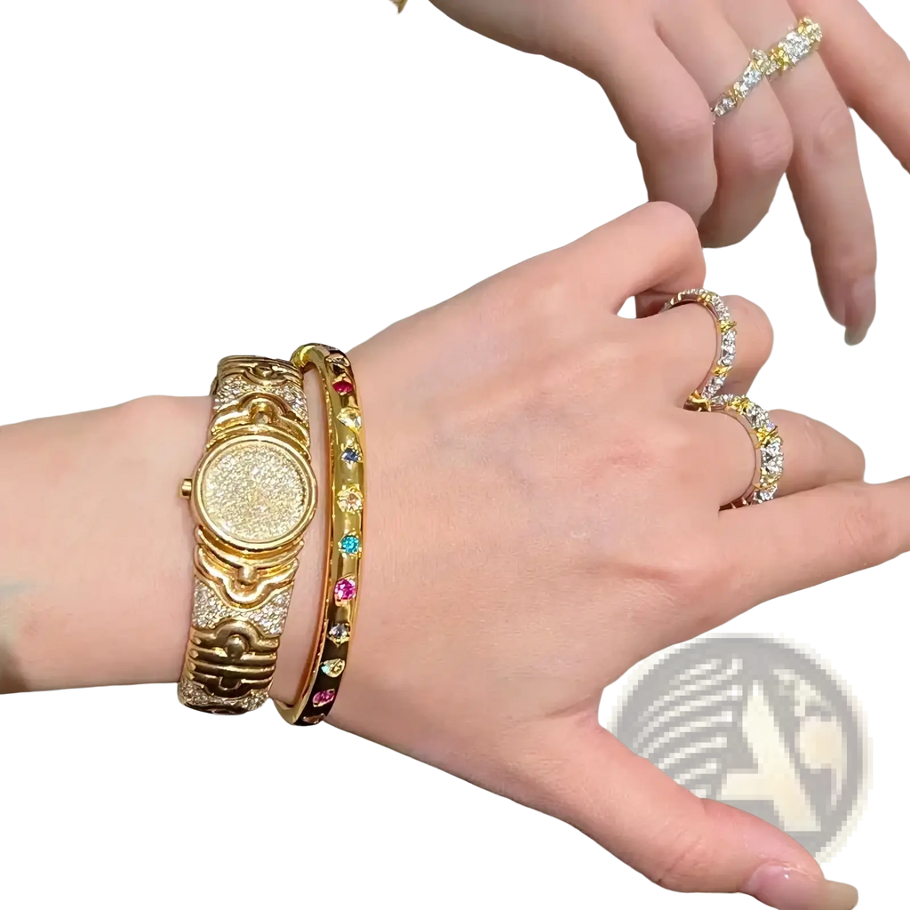 Gold-toned watch with a textured diamond-encrusted face and ornate detailing paired with a gold multicolored gemstone bangle bracelet
