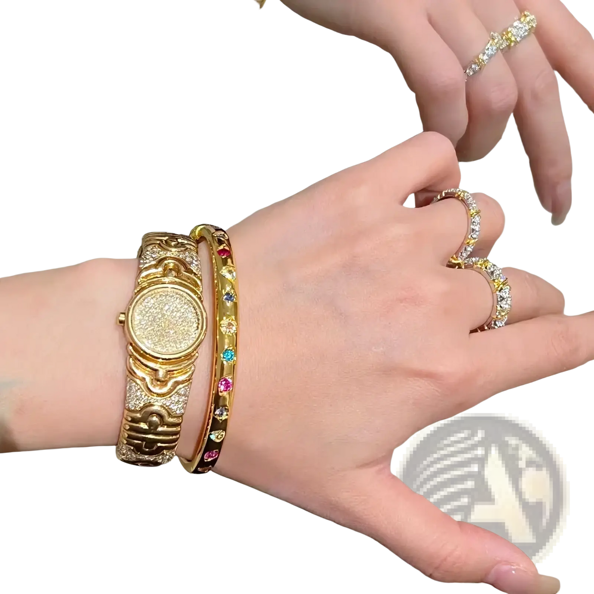 Gold-toned watch with a textured diamond-encrusted face and ornate detailing paired with a gold multicolored gemstone bangle bracelet