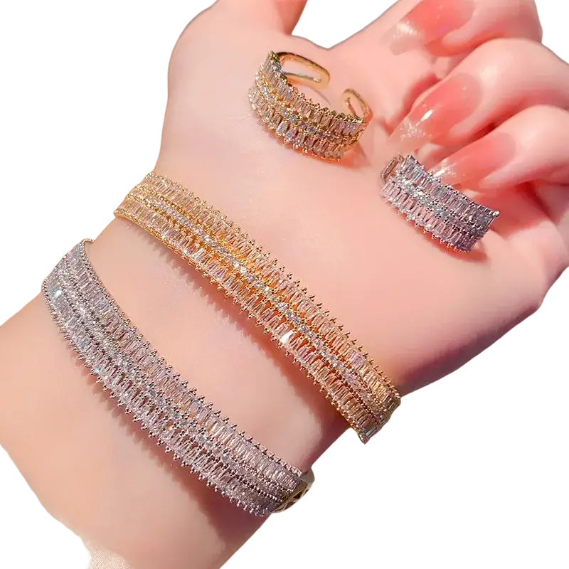 A set of elegant gold plated and silver tone multi layer bracelets and rings with sparkling baguette cut crystals
