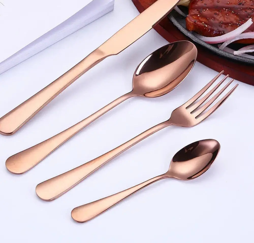 Luxury gold-plated stainless steel steak cutlery set in rose gold with sleek modern design and smooth reflective surfaces