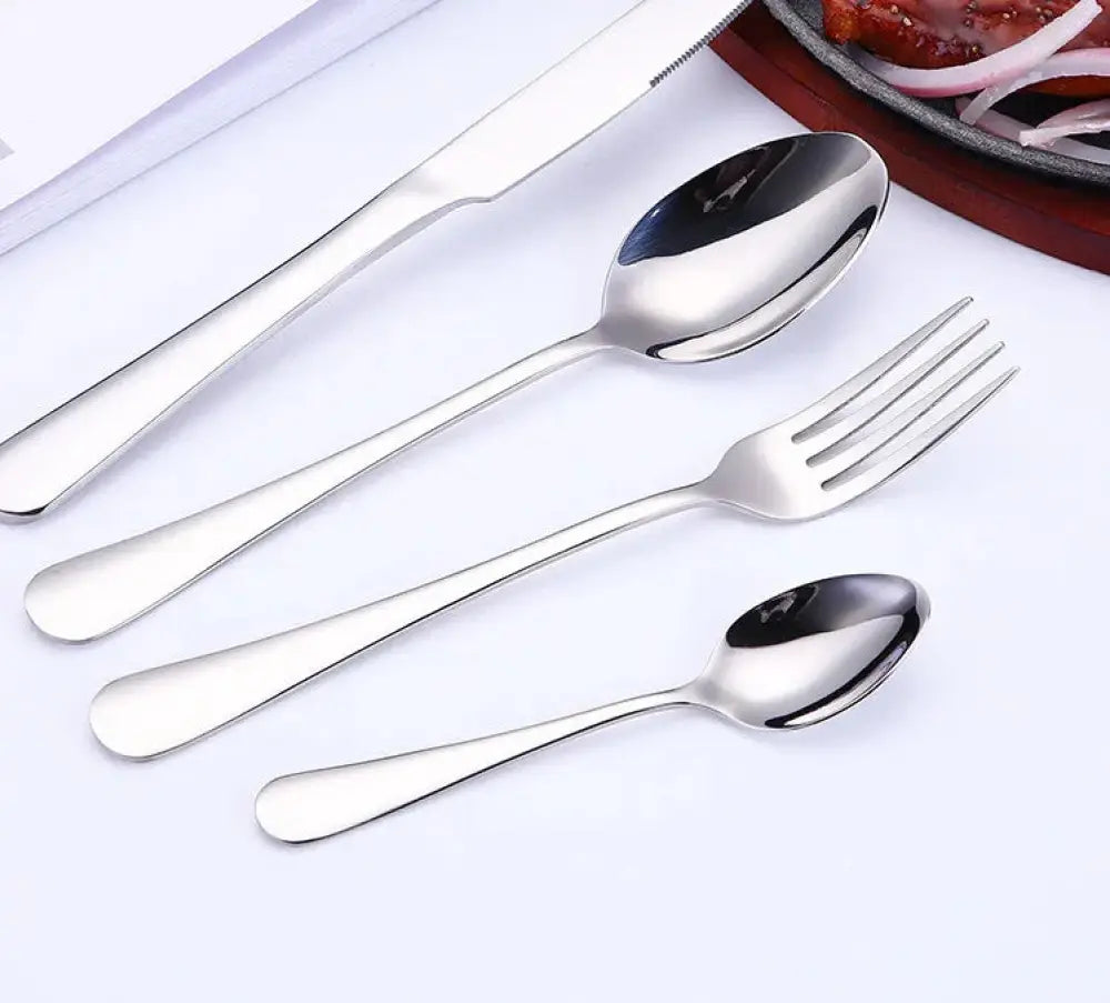 Luxury gold-plated stainless steel steak cutlery set featuring shiny knife fork and two spoons with modern handles