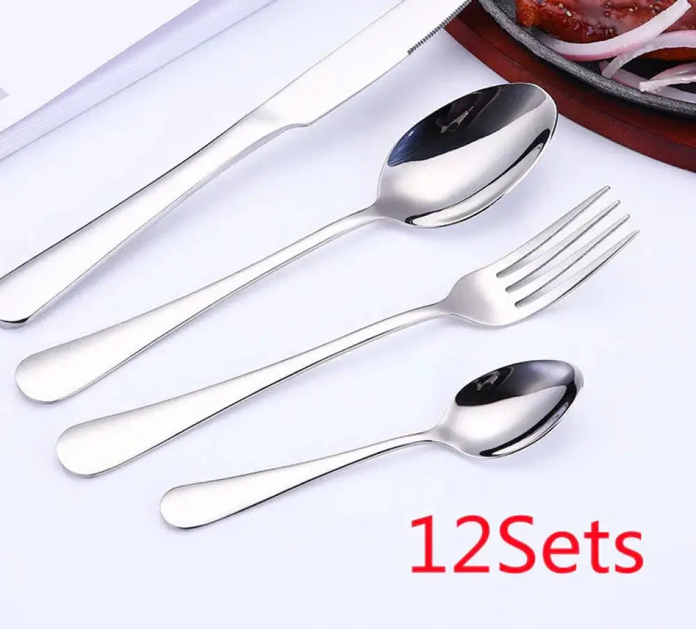 Luxury gold-plated stainless steel steak cutlery set with shiny knife fork and two spoons in sleek modern design