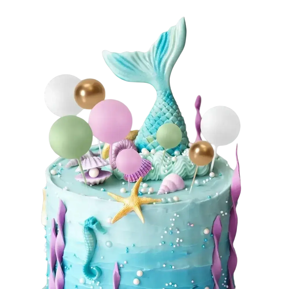 A pastel blue and purple mermaid cake with teal fish tail topper and seashells decorated with gold and silver foam ball cake toppers