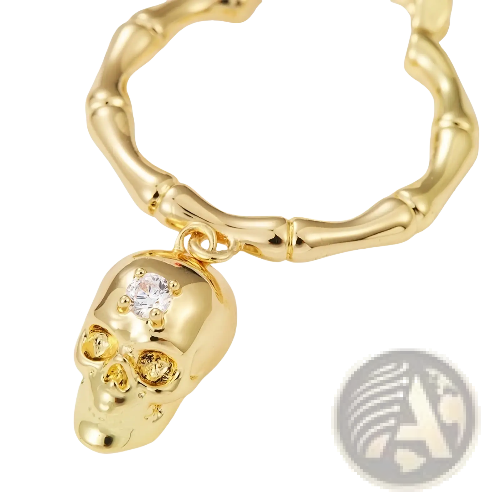 Gold skull tassel earrings featuring a gold-colored skull pendant with a clear crystal and bamboo-style chain