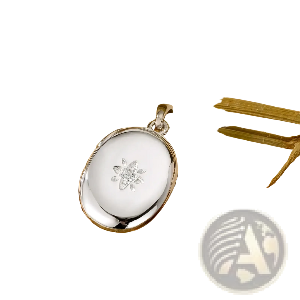Silver oval locket pendant with delicate diamond-studded flower design featured in gold starburst locket necklace
