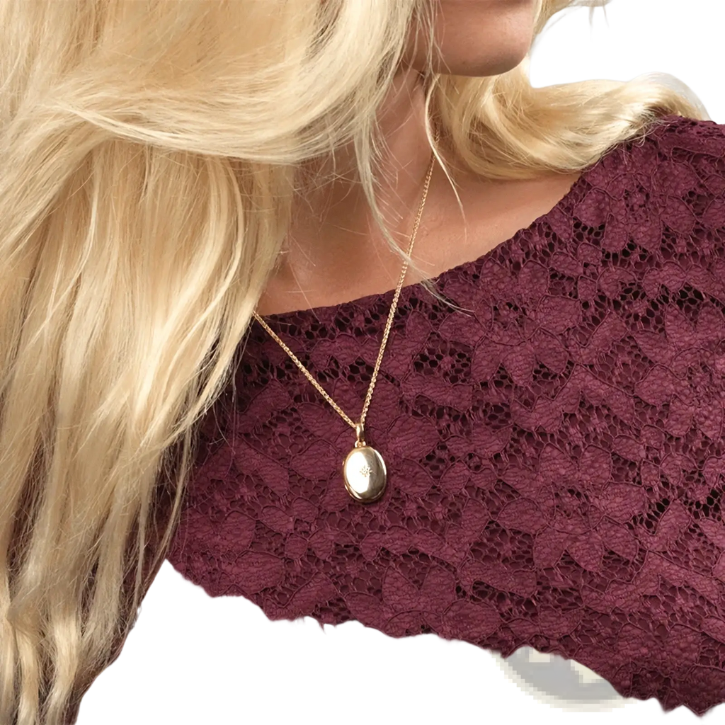 Gold starburst locket necklace with gold-toned oval pendant and delicate chain for elegant jewelry wear