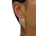 Gold tassel fringe statement earring with a gold-toned curved bar and delicate dangling chains for elegant wear