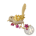 Golden bird brooch adorned with clear and yellow gemstones perched on pink ruby blossom branch clothing pin