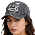 A faded gray cotton baseball cap embroidered with white love to golf text and a golf flag design