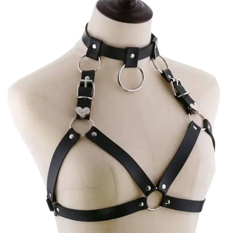Black goth body harness made of faux leather with silver metal rings and heart-shaped accents for body jewelry use