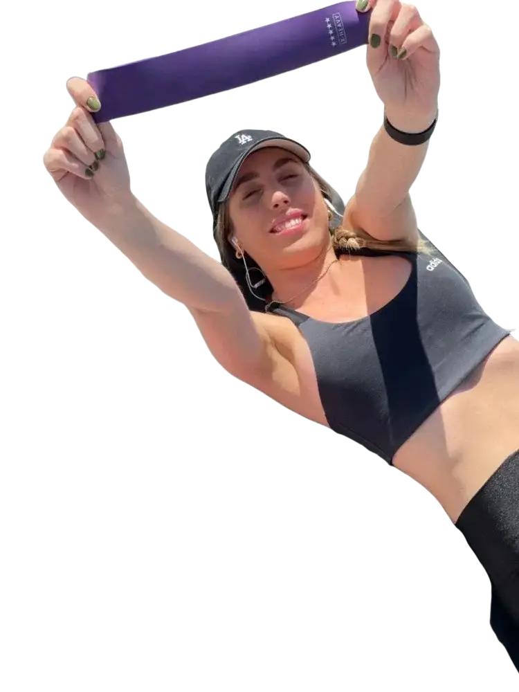 Gradient resistance bands set showing purple band held in hands with pink and orange bands laid out for workout use