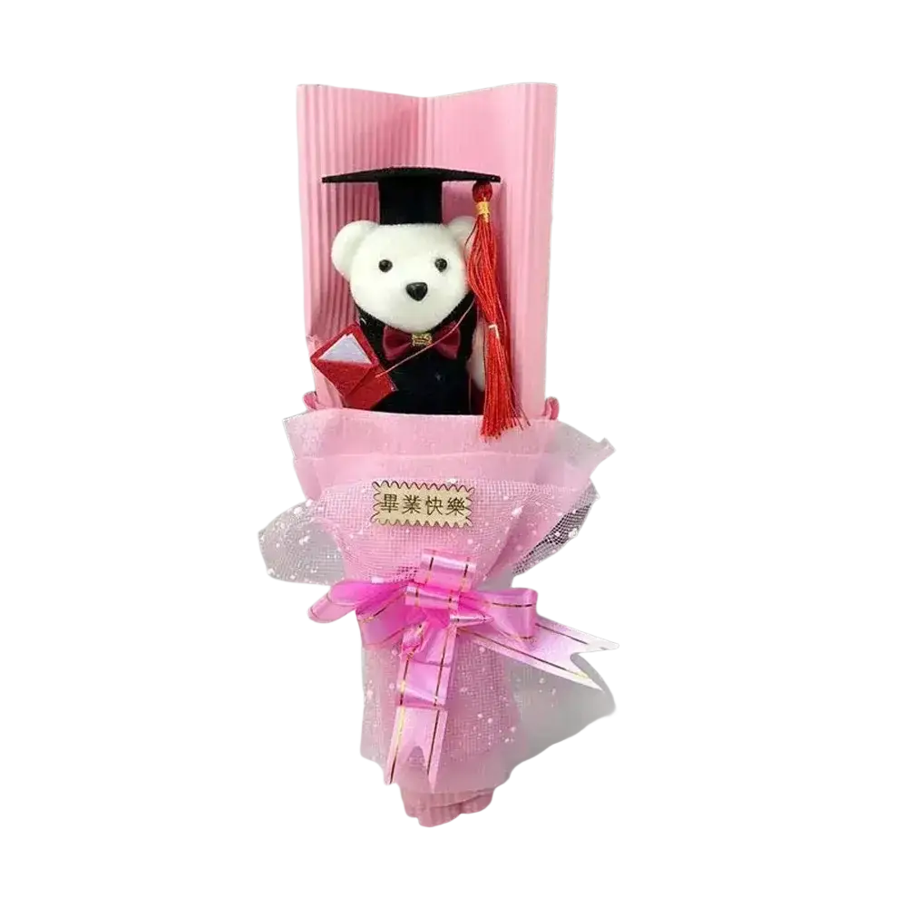 A plush white graduation bear dressed in black gown and red bow tie wrapped in pink tissue as a graduation bear bouquet