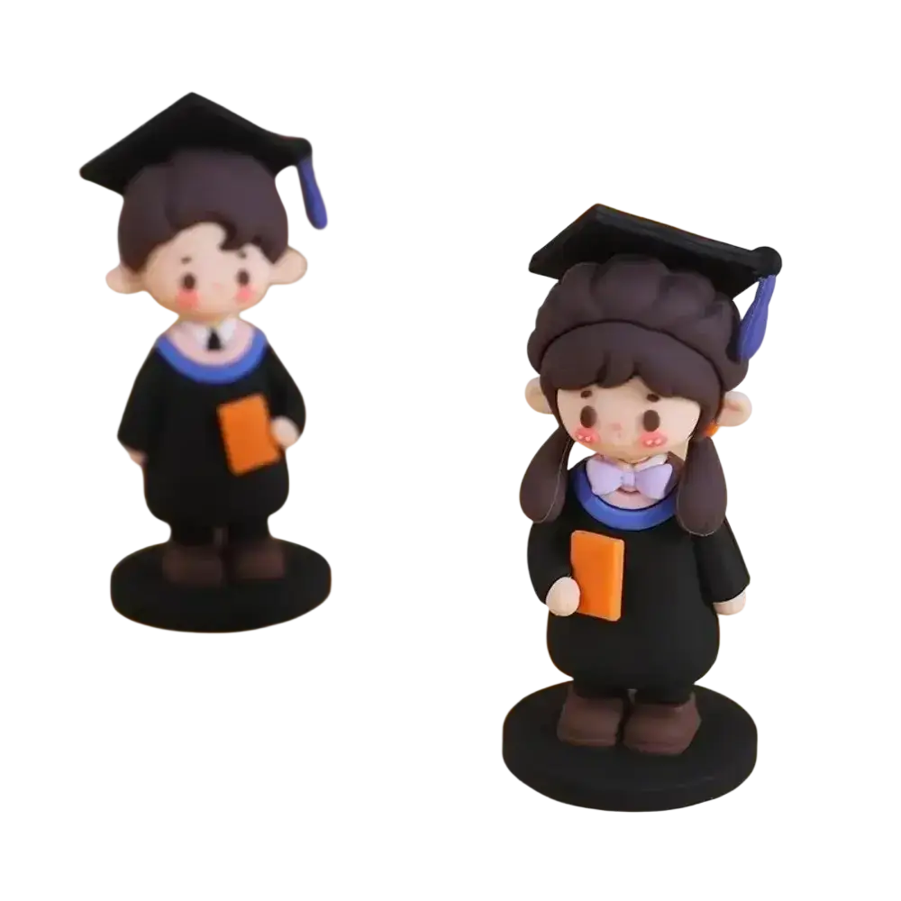 Cute black graduation cake topper figurines with blue accents and orange books featuring cartoon-style faces