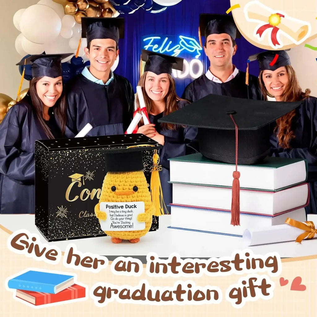 Yellow crocheted duck wearing a black graduation cap with red tassel holding a positive duck sign graduation gift 2025