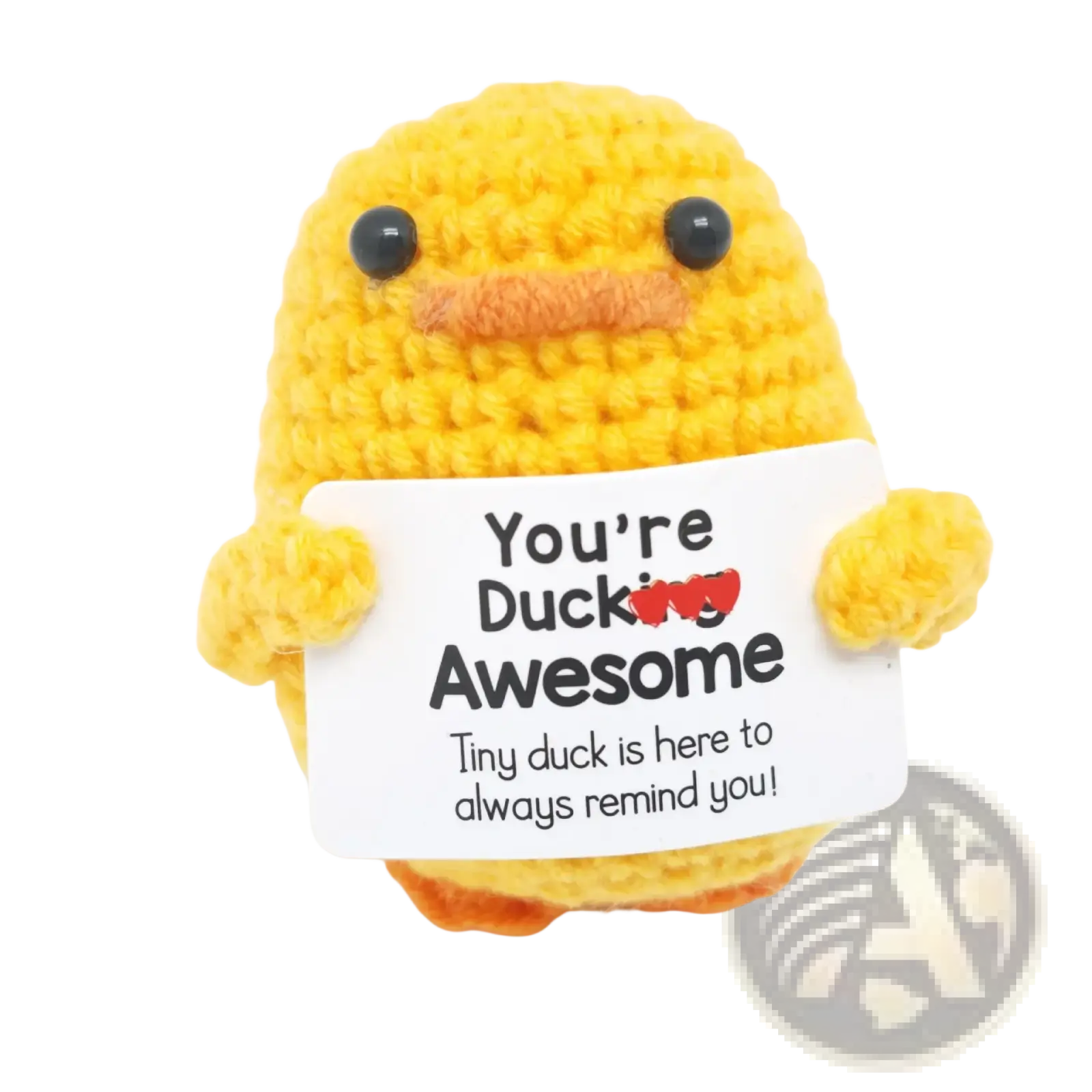 A yellow crocheted duck with black bead eyes and orange beak holding a white sign saying youre ducking awesome graduation gift 2025