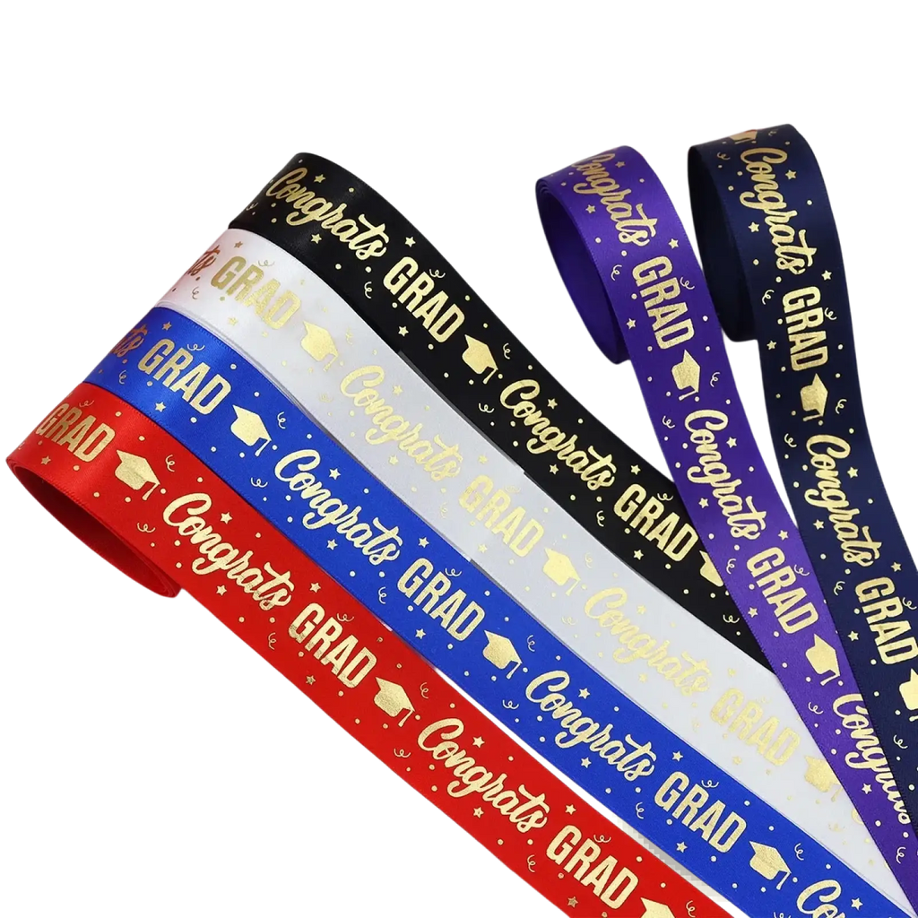A set of colorful satin graduation gift wrapping ribbons printed with congrats grad gold lettering and caps