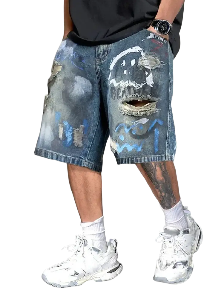 Graffiti distressed denim shorts for men featuring a faded wash blue fabric with ripped details and graffiti-style face design