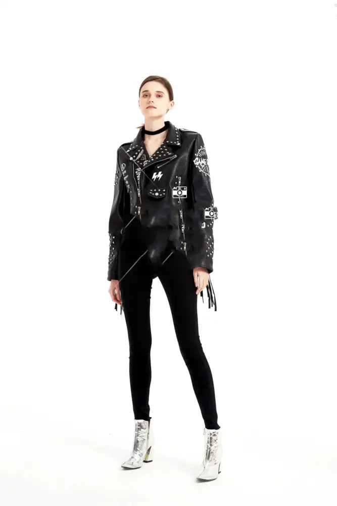 Black leather women’s biker jacket with white graphic patches and silver studs featuring graffiti rivet details