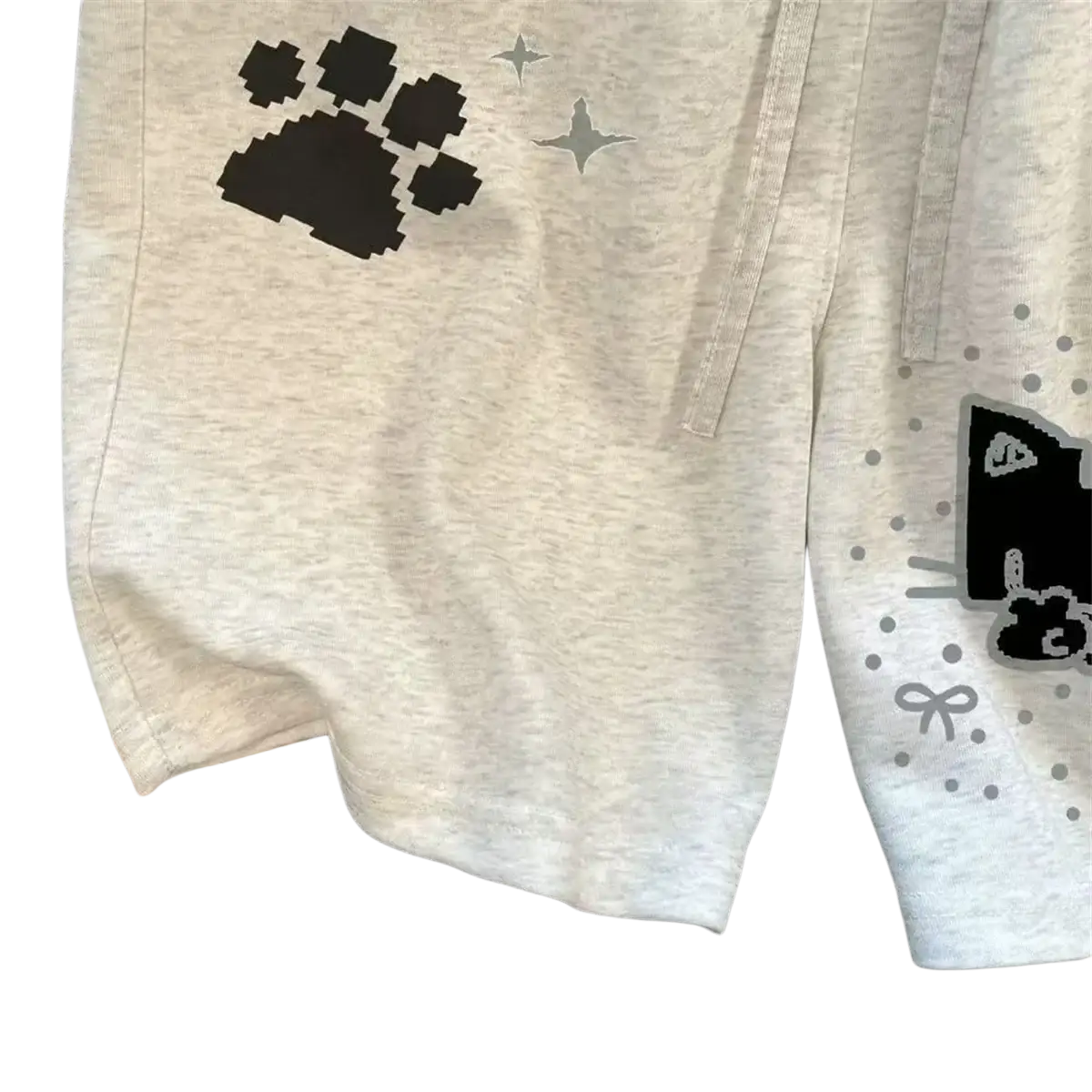Light gray heathered sweat shorts for women with black pixelated paw prints and silver star accents in y2k style