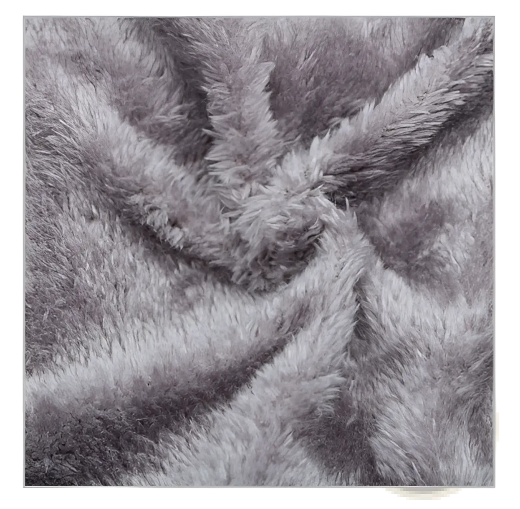 Soft gray faux fur blanket with a plush textured surface shown alongside a gray fleece lined knit beanie with metallic logo