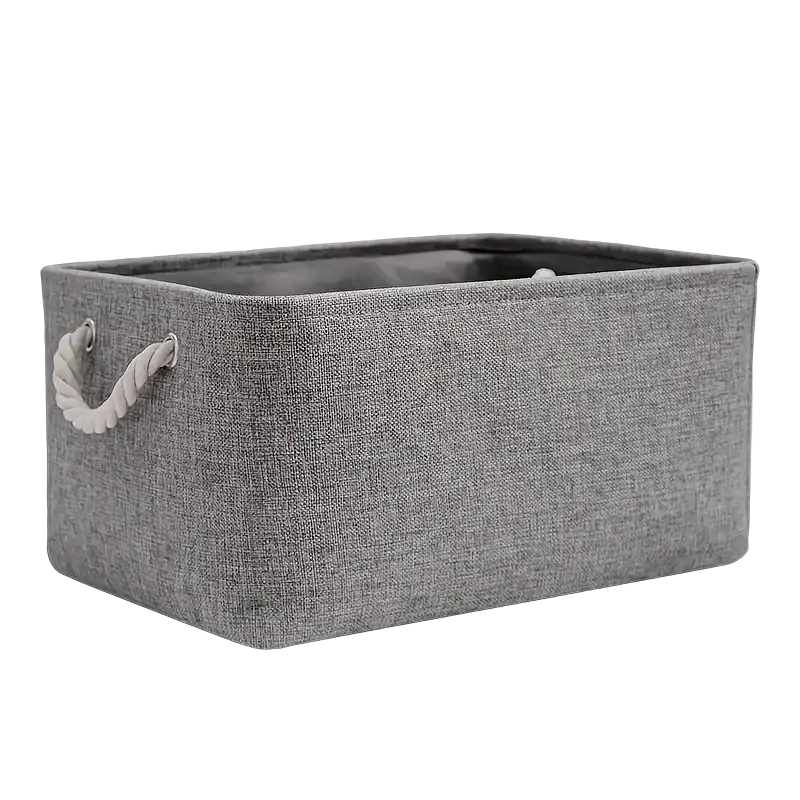 Gray foldable storage basket made of textured fabric with white twisted rope handles for use as a storage box