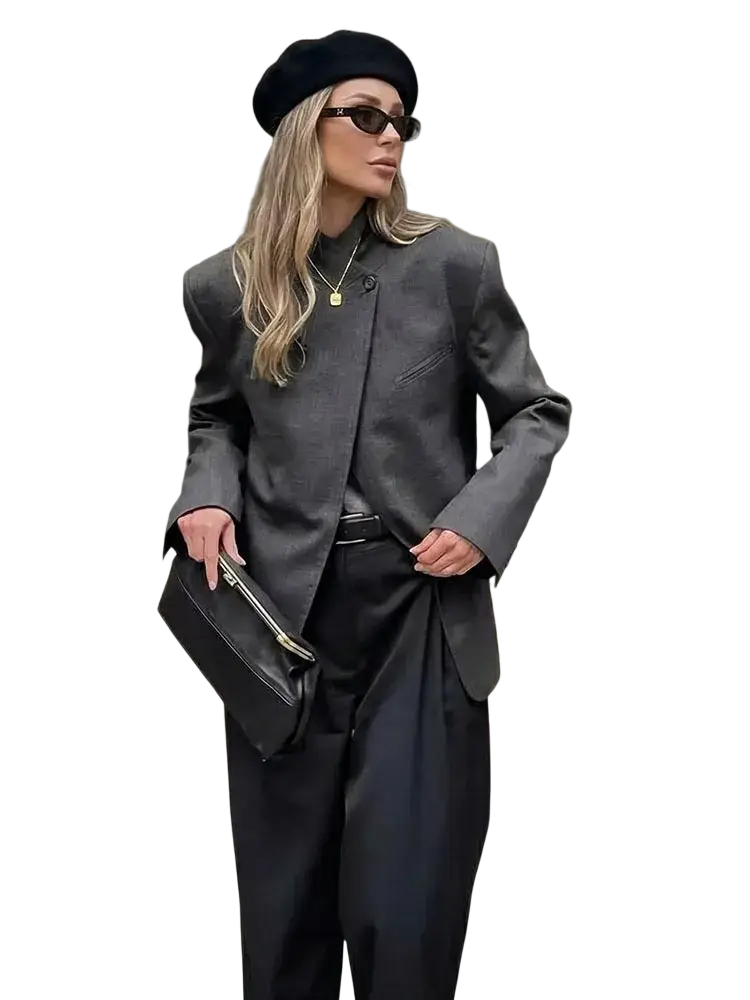 Black leather clutch with gold zipper pull complementing gray plaid oversized blazer for stylish occasions