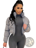 Gray short puffer jacket for women with high collar zipper front made of quilted synthetic material