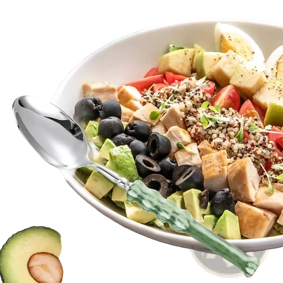 A sleek silver stainless steel serving spoon with a textured green glass handle beside a vibrant salad bowl