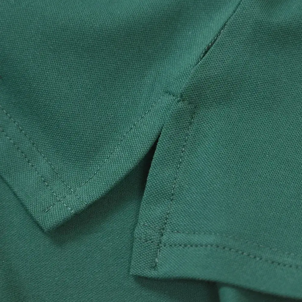 Dark green polo shirt collar with neat stitching and subtle textured weave on green golf bear embroidered polo shirt