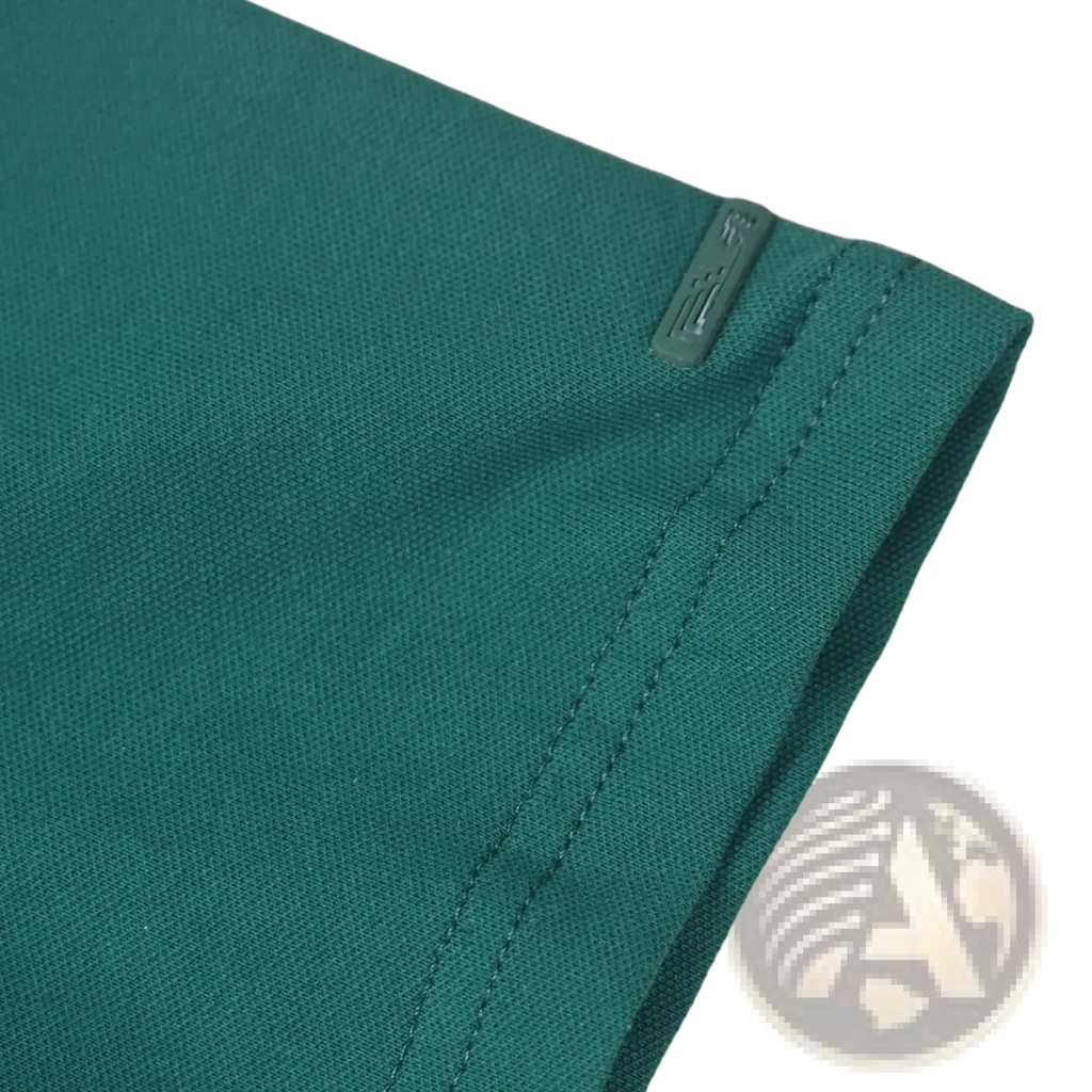 Teal woven fabric with subtle texture and stitched seam on green golf bear embroidered polo shirt