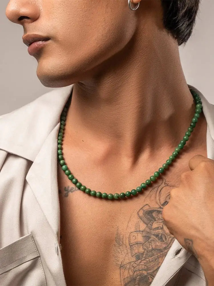A sleek dark green beaded necklace with uniformly sized round African green jade beads in gold stainless steel