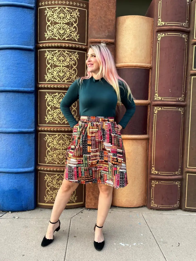 A-line skirt with colorful stacked books print paired with hunter green vintage stretch mock neck top
