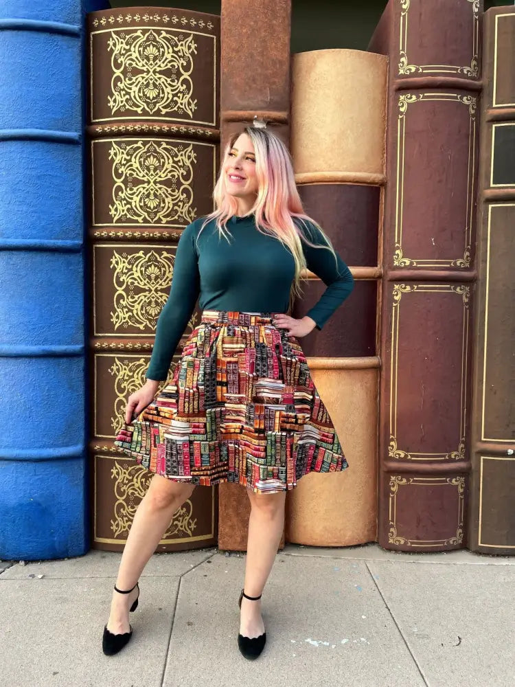 A vibrant a-line skirt with a colorful bookshelf pattern paired with a hunter green vintage stretch mock neck top